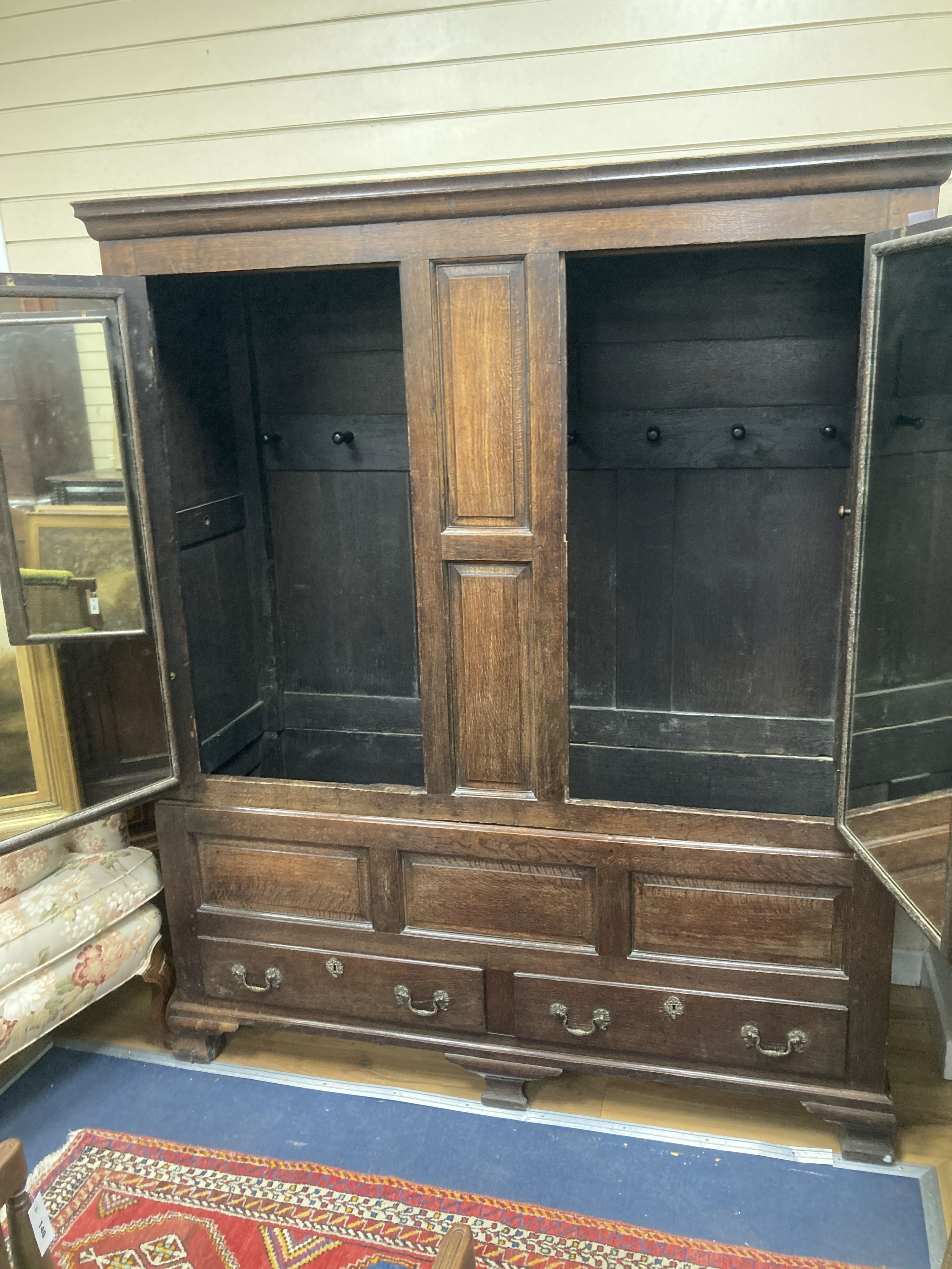 A mid 18th century oak panelled two part hanging cupboard, width 156cm, depth 53cm, height 188cm